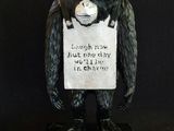 statue of a monkey holding a sign with a sign on it ' s head