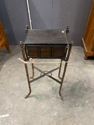 a small table with a drawer on it in the middle of a room