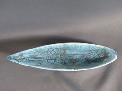 une assiette bleue avec un poisson dessus, posée sur une table