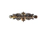 a close up of a brooch with pearls on it
