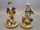 pair of figurines of a boy and a girl with chickens