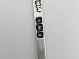 a silver spoon with writing on it sitting on a table