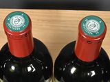 four bottles of wine in a wooden wine holder on a table