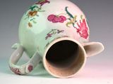 a white vase with a pink flower design on it
