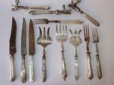 tout un service d'argenterie sur une table, comprenant un couteau, une fourchette, une cuillère et un repose-couteau