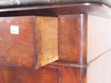 a close up of a wooden cabinet with a marble top