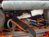 un sac posé par terre, rempli d'outils