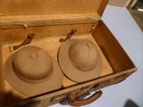 deux chapeaux dans une valise posée sur une table