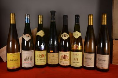several bottles of wine are lined up on a red table