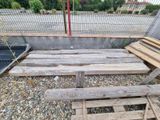 a pile of wood sitting on the ground next to a fence