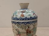 un petit vase posé sur une table, sur fond blanc