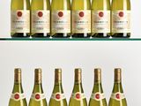 several bottles of wine are lined up on a glass shelf