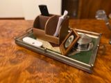 a wooden desk with a metal tray with a cell phone on it