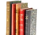 plusieurs vieux livres sont alignés sur une surface blanche