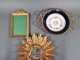 un soleil doré, un miroir et une assiette accrochés au mur