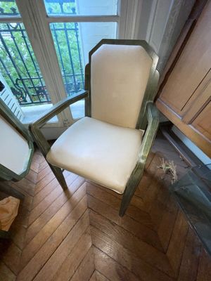 une chaise blanche placée devant une fenêtre dans une pièce