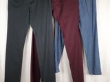 three pairs of jeans hanging on a clothes rack in front of a white curtain