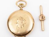 an image of a gold pocket watch sitting next to a tie bar