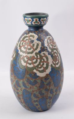un vase bleu et vert posé sur une surface blanche