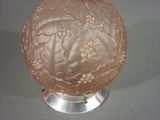 a glass ball on a metal stand on a table