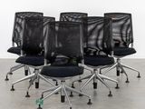 four black mesh office chairs with chrome steel legs and casteors