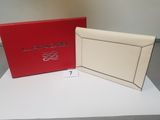 a white and red clutch bag next to a red box