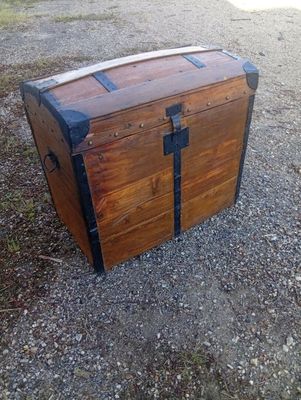 a wooden trunk sitting on the ground in the dirt