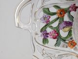 a white vase with flowers on it on a table