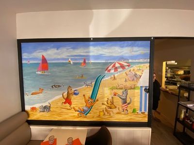 a picture of a painting of a beach scene on the wall