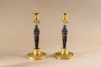 pair of antique brass candlesticks with figurines on bases