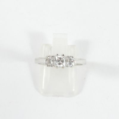 une photo d'une bague en diamant à trois pierres sur fond blanc