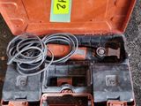 une boîte à outils orange contenant des outils, posée par terre