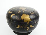 a black box with gold designs on it on a white surface