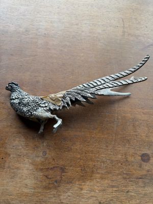 a metal bird that is sitting on a table