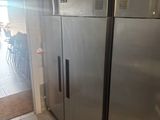 stainless steel refrigerators in a commercial kitchen with tiled flooring