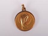 Gros plan sur une médaille d'or portant le visage d'une femme