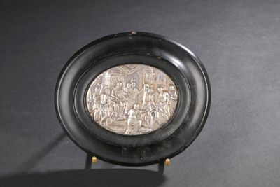 une assiette noire sur laquelle repose une pièce d'argent