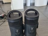 two black trash cans sitting on the floor next to each other