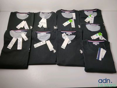 four men ' s black t - shirts are lined up on a table