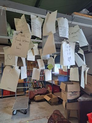 Plusieurs feuilles de papier sont suspendues au plafond d'une bibliothèque.