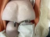 a doll that is sitting in a chair with a blanket over it