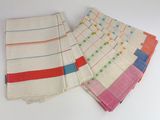four different colored striped napkins on a white surface