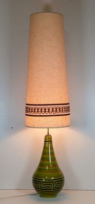 une lampe de table verte surmontée d'un abat-jour beige
