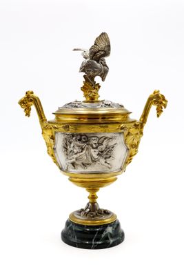une image représentant un vase en or et en argent surmonté d'un oiseau