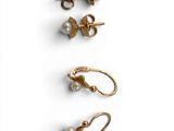 three pairs of gold earrings with pearls on them on a white surface
