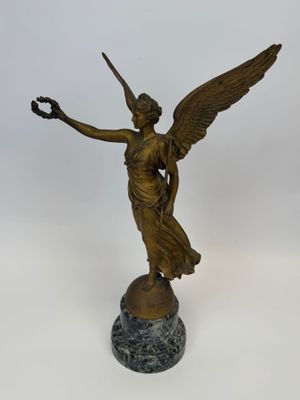 une image représentant une statue en bronze d'un ange tenant un oiseau