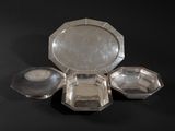 a silver plate with four compartments on a black surface