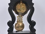 a black and gold clock sitting on a black stand