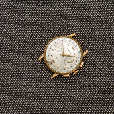 un gros plan d'une montre posée sur un morceau de tissu