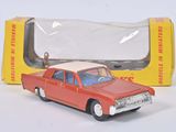 une petite voiture rouge devant une boîte jaune